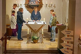 Die Wortgottesdiestleiterin Hiltrud Altenhöfer und die drei Jugenlichen stehen um den Altar in der Püssensheimer Kirche.