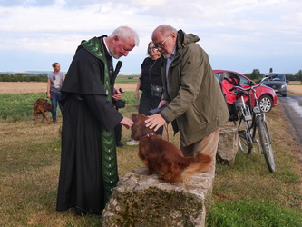 Auf diesem Bild streichelt Pater Matthäus einen kleinen Dackel.