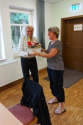 Eine Frau übergibt einem Mann ein Geschenk.