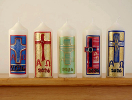 Fünf verzierte Osterkerzen stehen nebeneinander auf einem Foto-