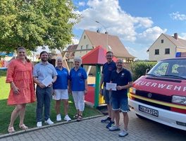 Das ist ein Gruppenbild mit sechs Personen. Alle schauen freundlich in die Kamera.