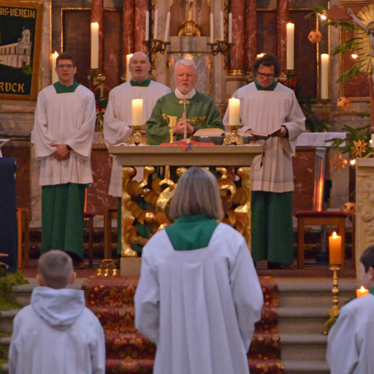 Eine Grupe mit vier Personen steht hinter dem Altar.