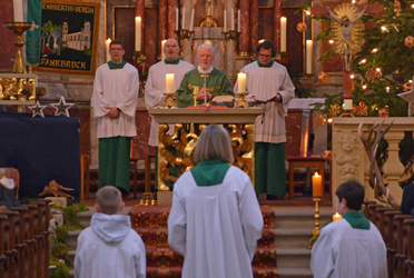 Eine Grupe mit vier Personen steht hinter dem Altar.