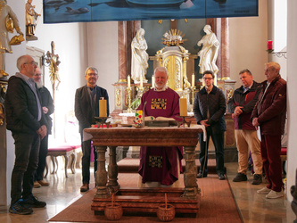 Blick von hinten auf den Altarraum. Dort steht Pater Matthäus am Altar.