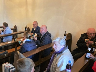 In den Kichenbänken sitzen Menschen und unterhalten sich.