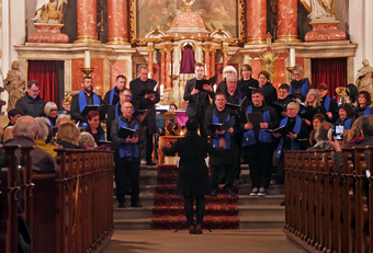 Auf den Altarstufen der Kirche steht ein Chor und singt