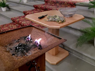 Die Feuerschale mit der Glut. Daneben liegen noch Palmzweige.