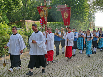 Beim Einzug zur Messe beim Hubertusfest 2024. Voraus gehen Ministranten mit der Fahne.