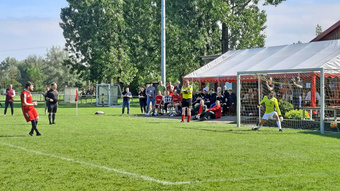 Eine klassische Elfmeter-Szene. Links steht der Schütze, rechts ist das Tor und dahinter sind Zuschauer.