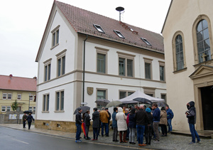 Eine Gruppe steht beim Sektempfang vor der Kirche St. Wolfgang