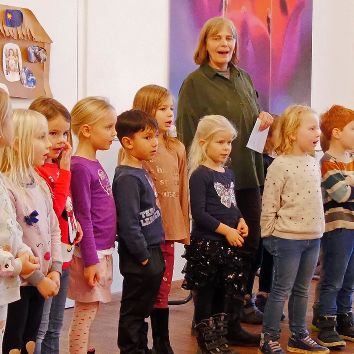 Kindergartenkinder und eine Erzieherinnen singen