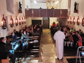 Blick vom Altarraum in die Kirche in Püssenheim. Es ist gerade Gottesdienst.