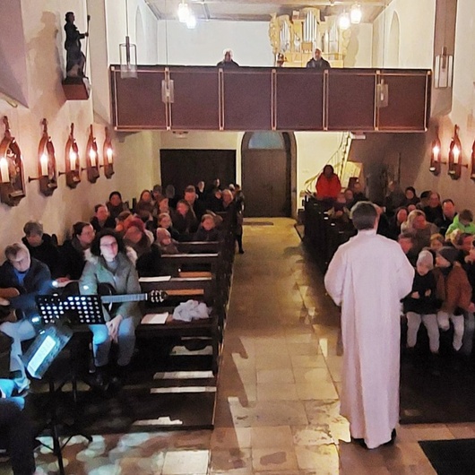Blick vom Altarraum in die Kirche in Püssenheim. Es ist gerade Gottesdienst.