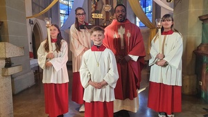 Gruppenbild mit dem neuen Ministranten im Vordergrund und weiteren Minis und dem Priester dahinter.