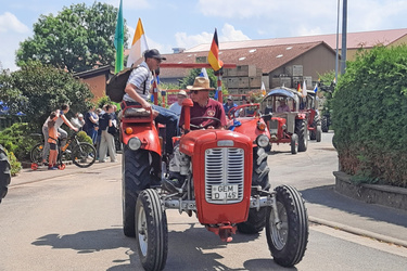 Eine ganze Reihe an Oldtimer-Traktoren sind zu sehen. Ganz vorn ist ein roter Traktor.
