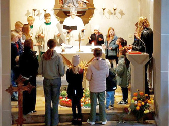 Kinder stehen um den geschmückten Altar in der Kirche.