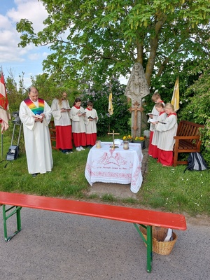 Um das Marterl herum haben sich die Ministrant:innen und der Leiter des Gottesdienstes aufgestellt.