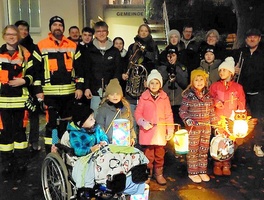 Ein Gruppenbild mit Laternen. Die Menschen schauen in die Kamera.