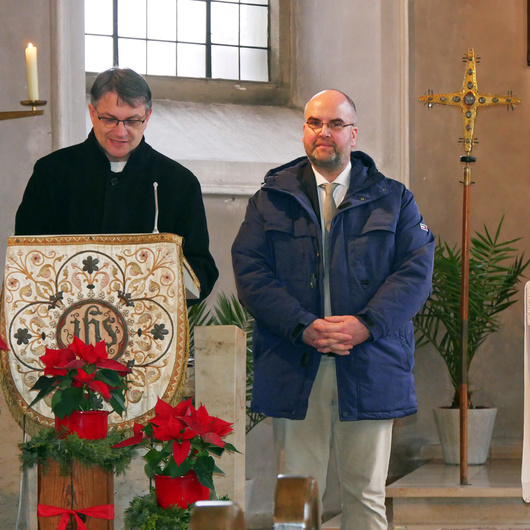 Der Kirchenpfleger und der Restaurator stehen nebeneinander am Ambo der Kirche in Unterpleichfeld.