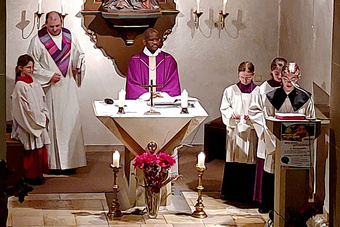 Pfarrer Benjamin Lubega steht am Altar in der Püssensheimer Kirche