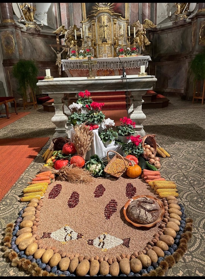 Vor dem Altar eine barocken Kirche ist ein Bodenbild aus Feldfrüchten gelegt mit den Symbolen von fünf Broten und zwei Fischen
