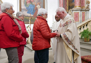 Rechts stehen die beiden Priester und links drei Frauen, die auf ihre Krankensalbung warten.