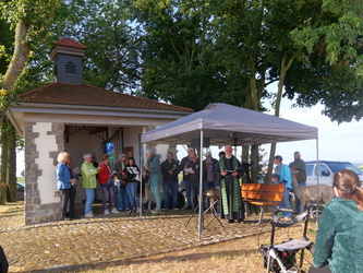 Blick hin zur Hubertuskapelle. Davor stehen Pater Matthäus und Mitglieder des Chores Chorisma aus Rieden.