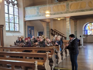 Musiker:innen sitzen in den Kirchenbänken und proben.
