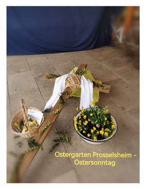 Ein liegendes Kreuz, das mit grünen Zweigen und Blumen dekoriert ist, als Symbol für den Ostersonntag.