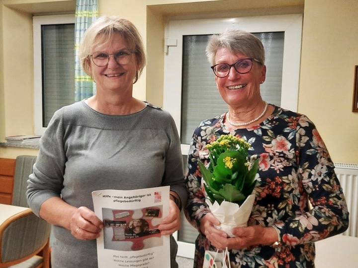 Zwei Frauen stehen nebeneinander und schauen in die Kamera. Sie freuen sich.