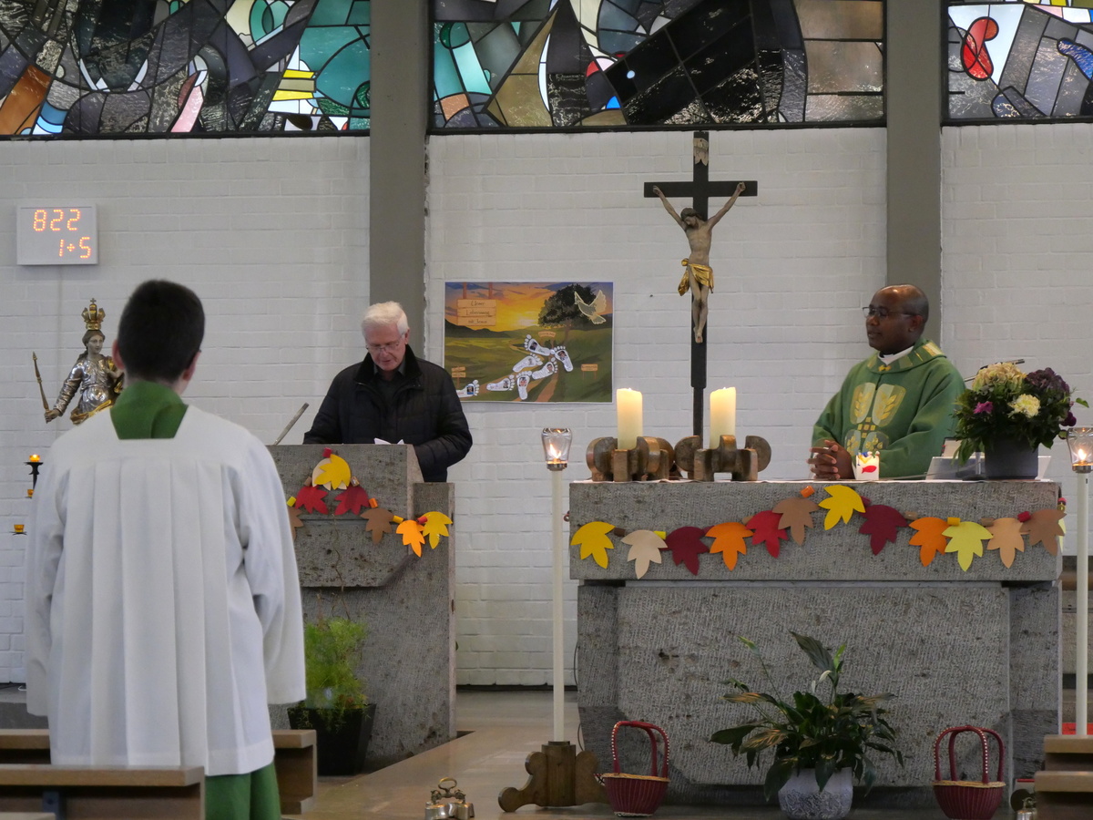 Das Foto ist in der Kirche aufgenommen. Man schaut auf den Altarraum. Links am Ambo steht Heinz Zimmermann. Rechts hinter dem Altar steht der Pfarrer.