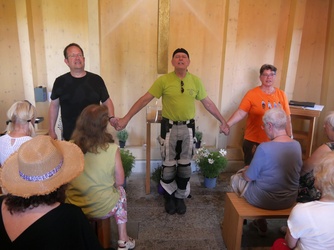 Drei Personen halten sich an den Händen und beten.