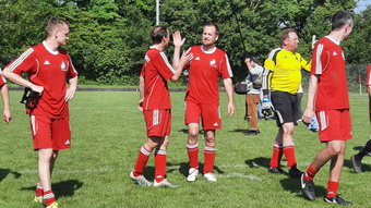 Fünf Männer in Trikots klatschen sich vor Freude über den Sieg ab.