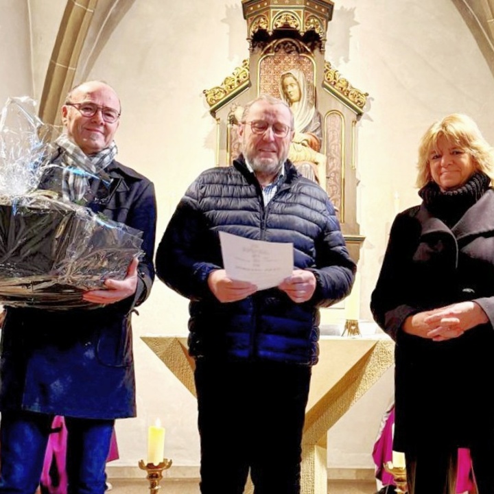 Auf dem Foto sind drei Personen mit Geschenken in den Händen. In der Mitte ist Norbert Brand.