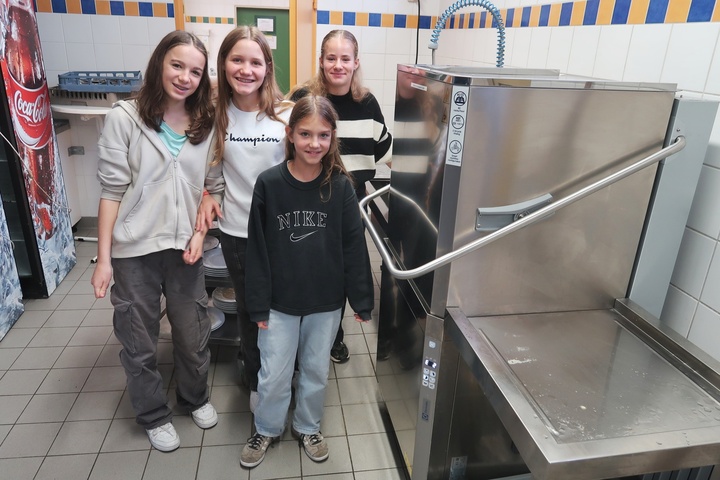 Vier Jugendliche schauen fröhlich in die Kamera.