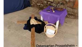 Ein Kreuz mit einem schwarzen Tuch, daneben auf einem kleinen Tisch Hammer und Nägel als Symbol für den Karfreitag.