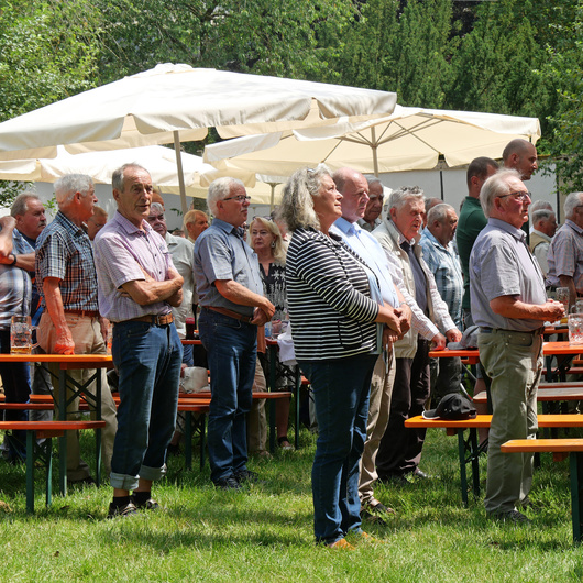 Männer stehen im Biergarten und singen das Ave Maria