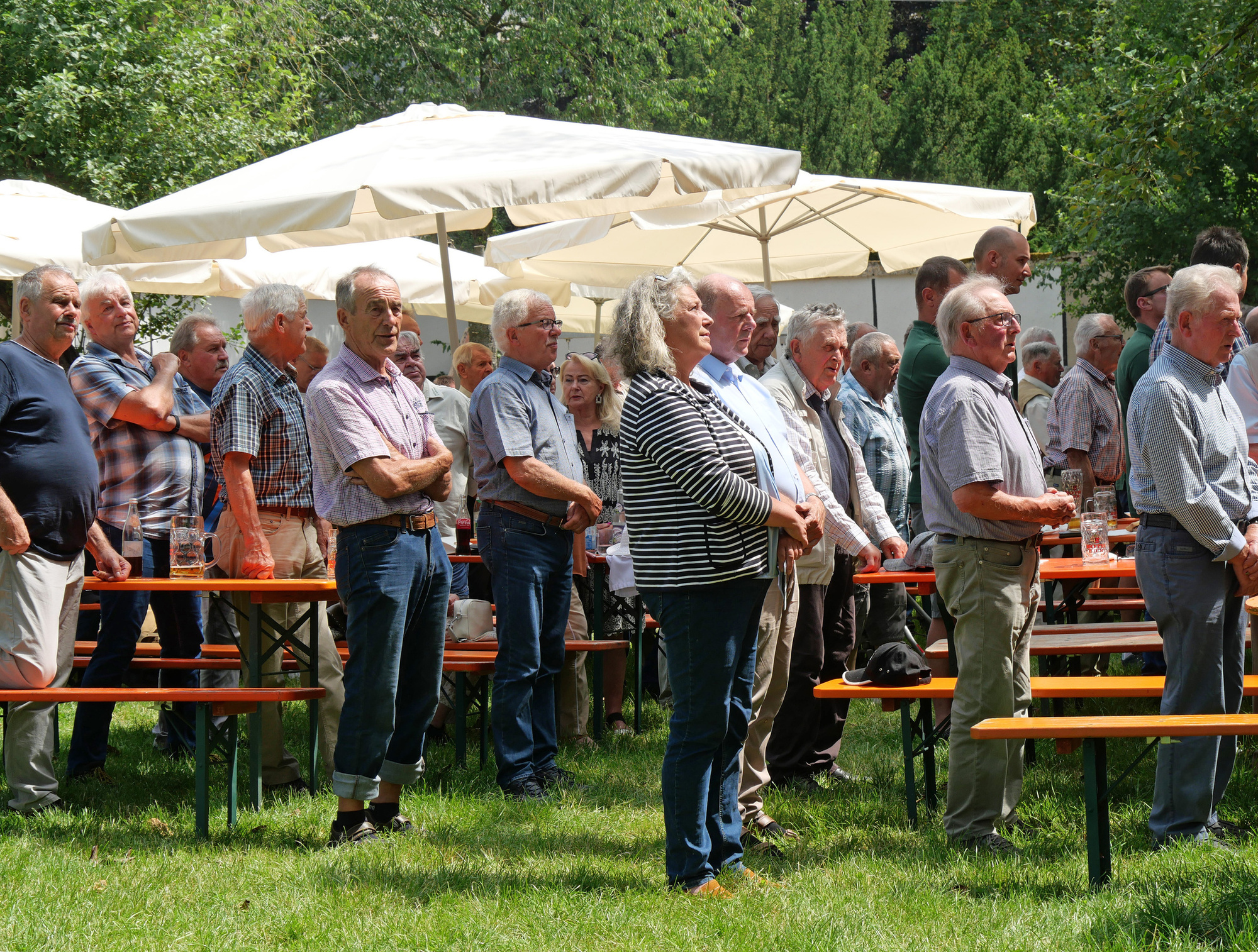 Männer stehen im Biergarten und singen das Ave Maria