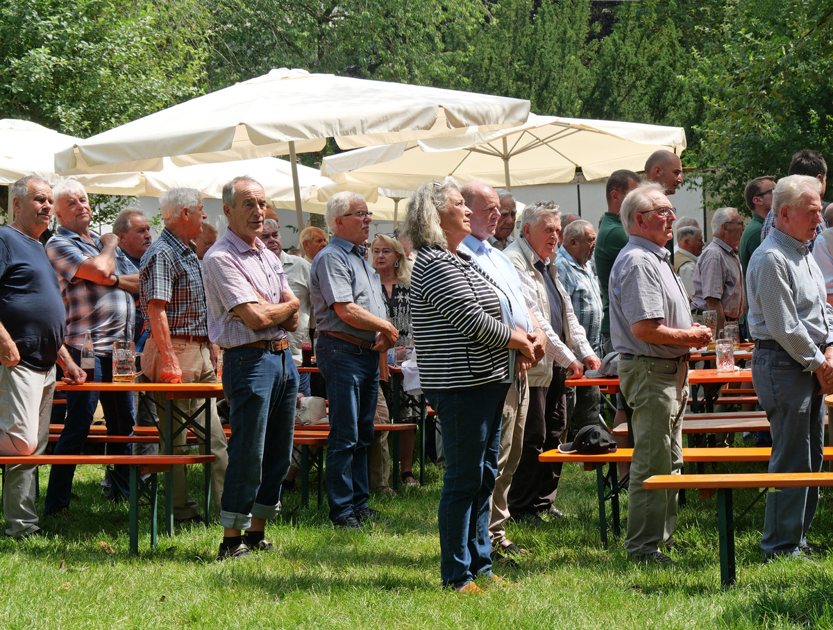 Männer stehen im Biergarten und singen das Ave Maria