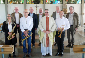 Ein Gruppenbild mit neun Personen vor dem Altar der Kirche in Erbshausen.