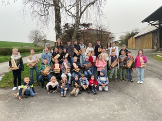 Ein Gruppenbild mit vielen Kindern und Jugendlichen und ihren Rappelkästen