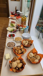 Auf einer langen Theke stehen mehrere Teller und Schalen mit leckerem Essen.