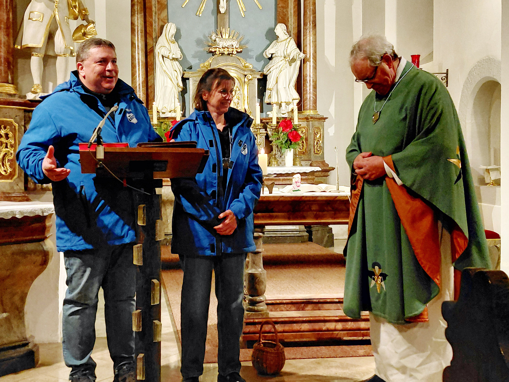 André und Sonja Ziegler übergeben Pfarrer Rügamer in der Kirche den Orden.