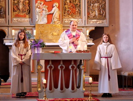 Am Altar der Kirche in Opferbaum steht in der Mitte der Pastoralreferent und rechts und links davon die Firmlinge.