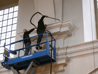 Zwei Männer in der Scherenhebebühne mit dem Staubsauger.