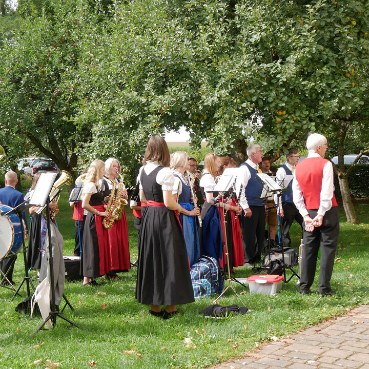 Augustinerpater Matthäus Klein wird von einer Musikkapelle in fränkischer Tracht begrüßt.