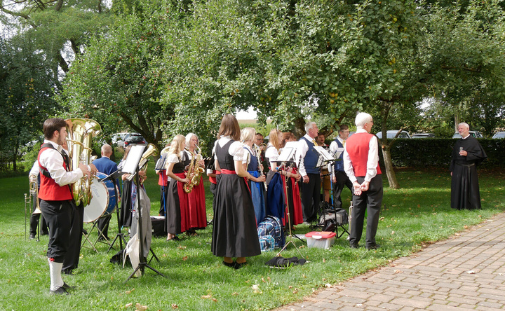 Augustinerpater Matthäus Klein wird von einer Musikkapelle in fränkischer Tracht begrüßt.