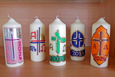 Auf dem Bild sind fünf verzierte Osterkerzen zu sehen.