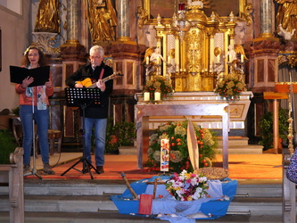 Auf dem Foto sieht man die schöne Kirche in Gramschatz von innen. Links stehen eine Frau und ein Mann. Sie singen.