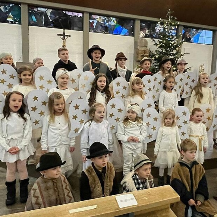 Eine große Kindergruppe steht als verkleidete Engel in der Erbshausener Kirche.